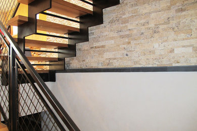 Imagen de escalera suspendida actual grande sin contrahuella con escalones de madera y barandilla de metal