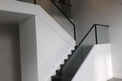 Ejemplo de escalera en U minimalista grande con escalones de madera pintada, contrahuellas de madera pintada y barandilla de varios materiales