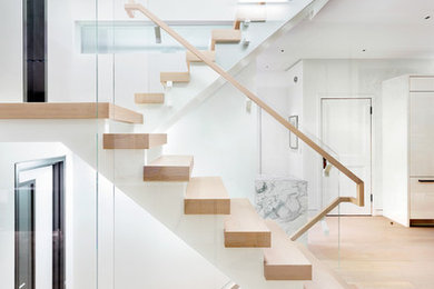 Large minimalist wooden straight open and wood railing staircase photo in New York