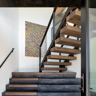 Inspiration pour un escalier chalet avec des marches en bois, des contremarches en béton et un garde-corps en métal.