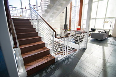 他の地域にある広いコンテンポラリースタイルのおしゃれな階段 (木の蹴込み板) の写真