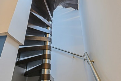Photo of a medium sized modern wood l-shaped glass railing staircase in Tampa with open risers.