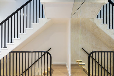 Photo of a contemporary painted wood straight staircase in London with painted wood risers.
