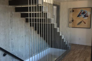 Example of a large minimalist wooden straight cable railing and open staircase design in Orange County