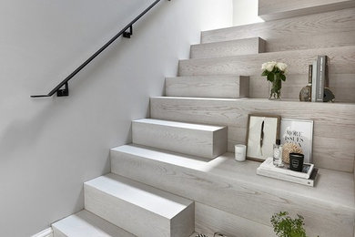 Diseño de escalera en U contemporánea de tamaño medio con barandilla de metal, escalones de madera y contrahuellas de madera