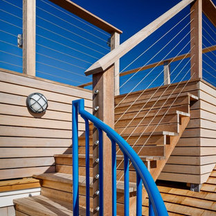 Imagen de escalera en L, costera, pequeña, con escalones de madera, contrahuellas de madera y barandilla de metal