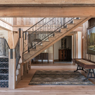 Idée de décoration pour un grand escalier chalet en L et bois avec des marches en moquette, des contremarches en moquette et un garde-corps en métal.