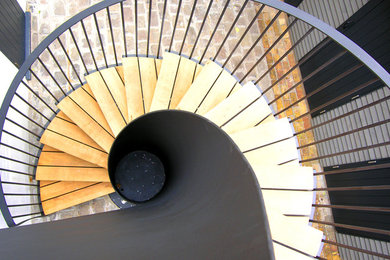 Imagen de escalera de caracol actual con escalones de madera y contrahuellas de metal