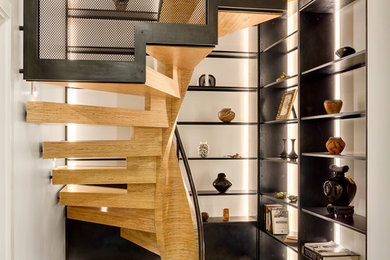 Modelo de escalera de caracol minimalista grande con escalones de madera, contrahuellas de madera y barandilla de metal