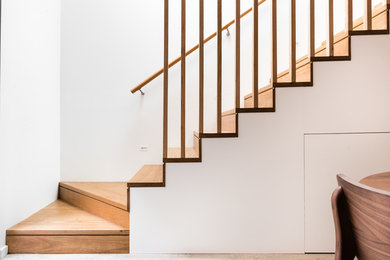 Foto de escalera en L contemporánea pequeña con escalones de madera, contrahuellas de madera y barandilla de madera