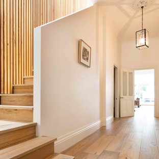 Ejemplo de escalera en L, contemporánea, grande, con escalones de madera y contrahuellas de madera