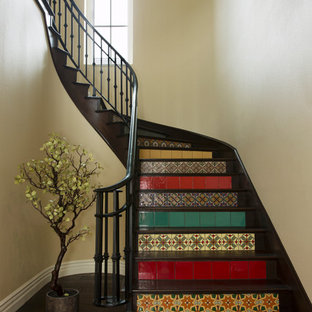 Ejemplo de escalera curva, mediterránea, con escalones de madera y contrahuellas con baldosas y/o azulejos