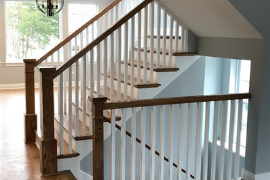 Example of an arts and crafts wooden u-shaped wood railing staircase design in Chicago with wooden risers