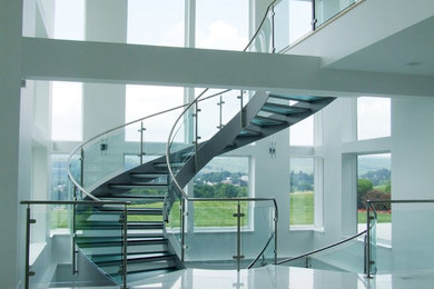 This is an example of a large modern curved staircase in Philadelphia with open risers.