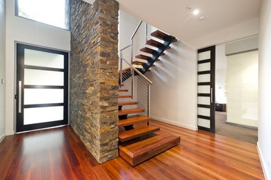 Large trendy wooden u-shaped open staircase photo in Melbourne