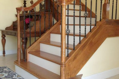 Elegant wooden l-shaped staircase photo in Miami with painted risers