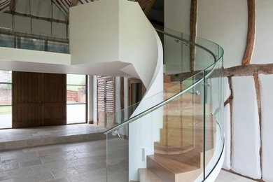 Inspiration for a country wood curved staircase in Sussex with metal risers.
