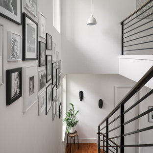 Cette image montre un escalier sans contremarche droit nordique de taille moyenne avec des marches en bois et un garde-corps en métal.