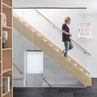 Inspiration pour un escalier droit nordique avec des marches en bois et un garde-corps en verre.