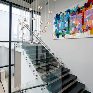 Idées déco pour un escalier moderne de taille moyenne avec des marches en bois et des contremarches en verre.