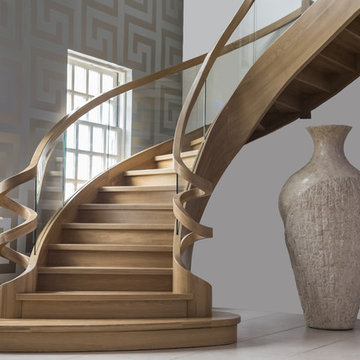 oak curved staircase with a roller coaster balustrade