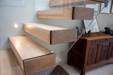 Imagen de escalera recta contemporánea de tamaño medio con escalones de madera y barandilla de varios materiales