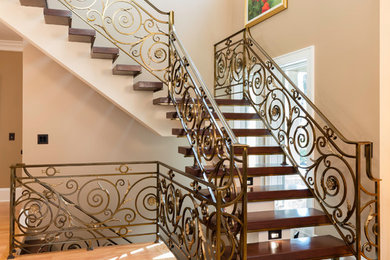 Example of a large tuscan wooden l-shaped open and metal railing staircase design in New York