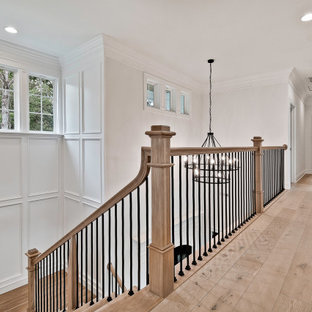 Foto de escalera en U y boiserie, de estilo americano, grande, con escalones de madera, contrahuellas de madera, barandilla de varios materiales y boiserie