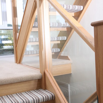 Open-tread oak staircase renovation with embedded glass balustrade