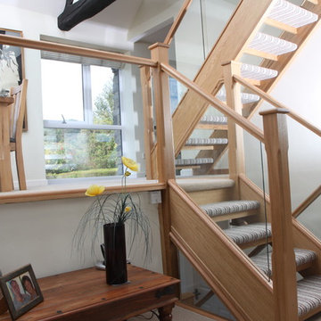 Open-tread oak staircase renovation with embedded glass balustrade
