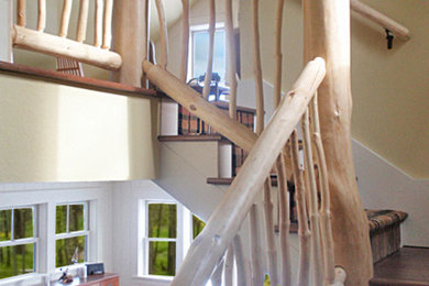 Ejemplo de escalera en L rústica de tamaño medio con escalones enmoquetados, contrahuellas enmoquetadas y barandilla de madera