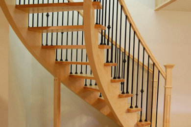 Modelo de escalera curva de tamaño medio con escalones de madera y contrahuellas de madera pintada