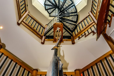 Imagen de escalera de caracol marinera grande con escalones de madera, contrahuellas de madera y barandilla de metal