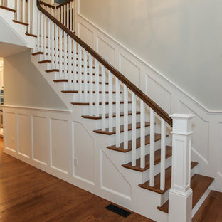 Esempio di un'ampia scala a "L" stile americano con pedata in legno e alzata in legno verniciato