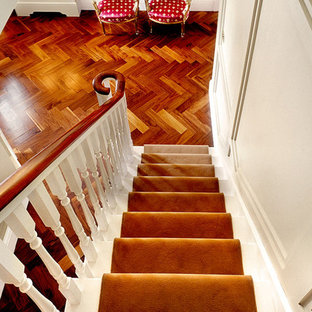 Imagen de escalera recta, tradicional, de tamaño medio, con escalones enmoquetados, contrahuellas enmoquetadas y barandilla de madera