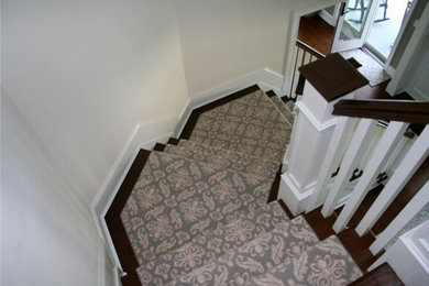 Mid-sized wooden curved staircase photo in New York with carpeted risers