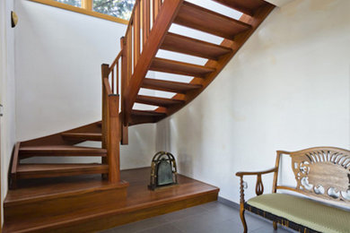 Staircase - mid-sized eclectic wooden curved open and wood railing staircase idea in Montreal