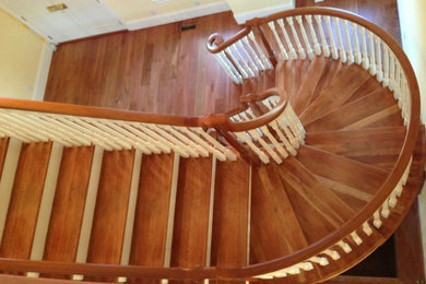Foto de escalera de caracol grande con escalones de madera y contrahuellas de madera