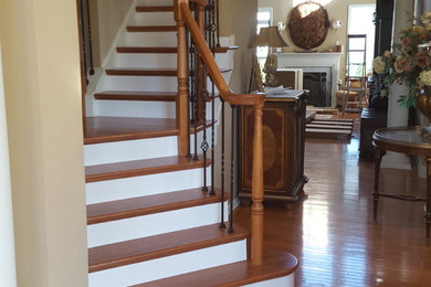 Foto de escalera en L tradicional de tamaño medio con escalones de madera, contrahuellas de madera pintada y barandilla de metal