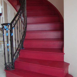 Ejemplo de escalera curva, de estilo americano, grande, con escalones de madera pintada y contrahuellas de madera pintada