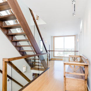 Modelo de escalera recta, actual, grande, con escalones de madera, contrahuellas de vidrio y barandilla de vidrio