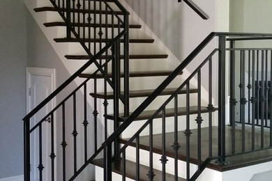 Imagen de escalera en L tradicional renovada de tamaño medio con escalones de madera, contrahuellas de madera pintada y barandilla de metal