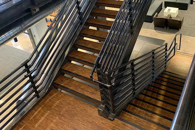 Modelo de escalera en U urbana grande sin contrahuella con escalones de madera y barandilla de metal