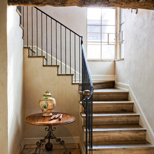 Staircase - rustic wooden u-shaped metal railing staircase idea in Phoenix with wooden risers