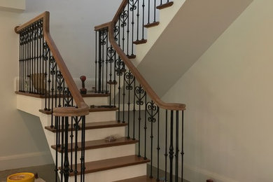 Foto de escalera en U clásica de tamaño medio con escalones de madera, contrahuellas de madera pintada y barandilla de madera