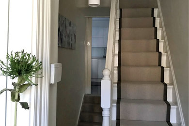 This is an example of a medium sized contemporary painted wood wood railing staircase in London with painted wood risers.