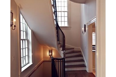 Large elegant wooden spiral staircase photo in Charlotte with painted risers