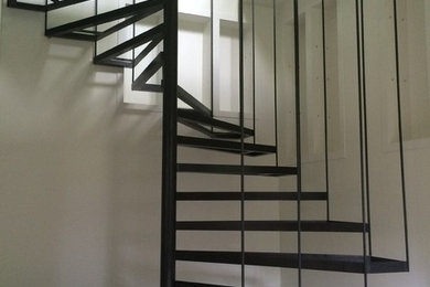 Ejemplo de escalera de caracol sin contrahuella con escalones de metal y barandilla de metal