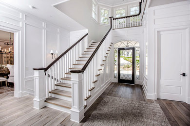 Example of a classic wooden u-shaped wood railing staircase design in Los Angeles with wooden risers