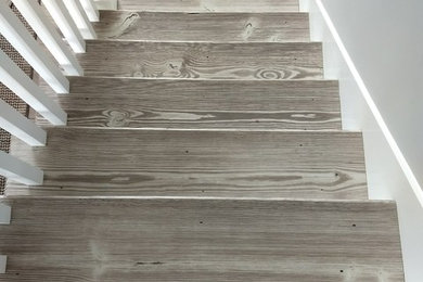 Modelo de escalera recta actual con escalones de madera, contrahuellas de madera y barandilla de madera